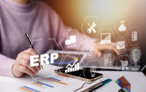 A person using a laptop for ERP with different ERP related icons on the screen