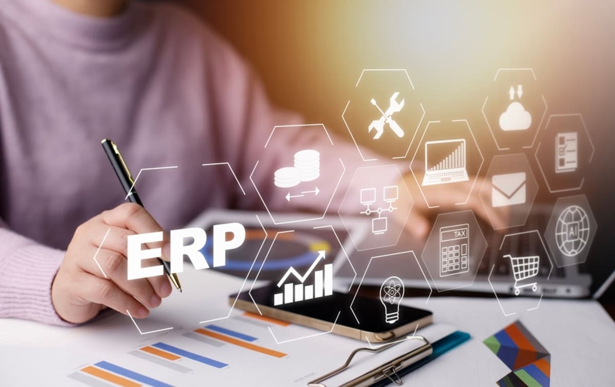 A person using a laptop for ERP with different ERP related icons on the screen
